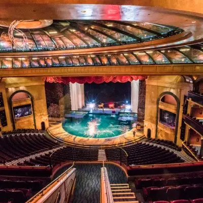 A view of the inside of the theater with a pool of water on the stage