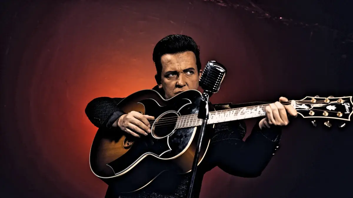 Johnny Cash impersonator posing with a guitar in his hands