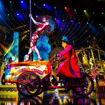 Acrobat in red performs in a colorful Cirque du Soleil scene