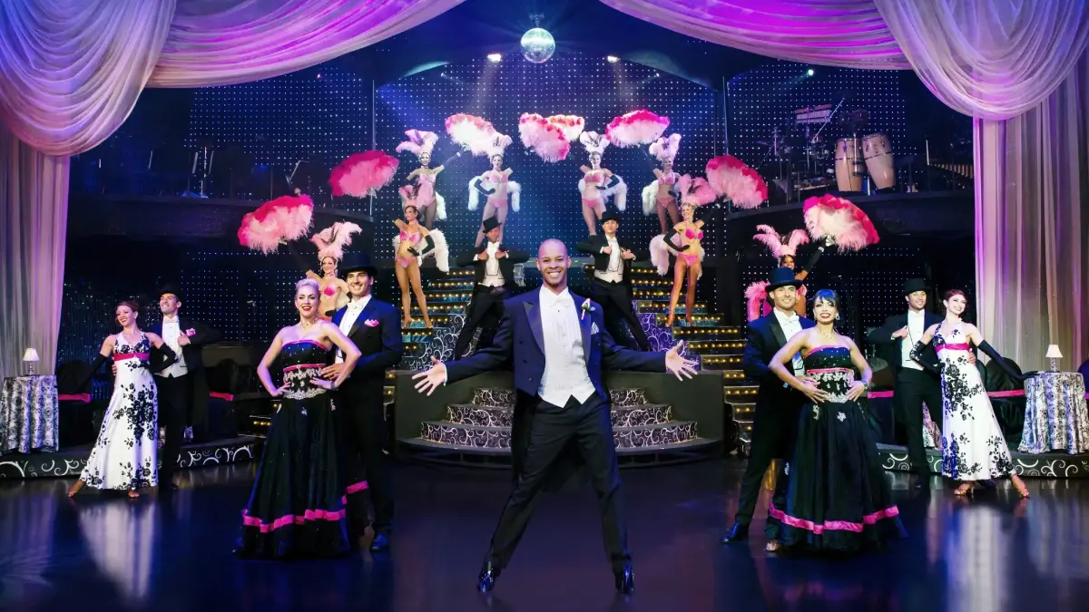 Performers in elegant costumes pose on stage at VEGAS! THE SHOW