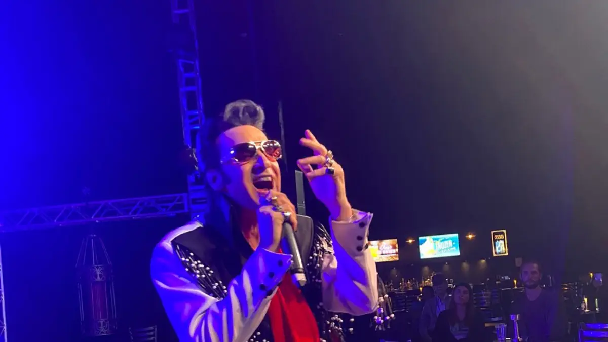 The Elvis impersonator performing while on his knees