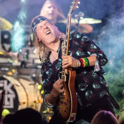 A musician from the band holding a guitar in Las Vegas