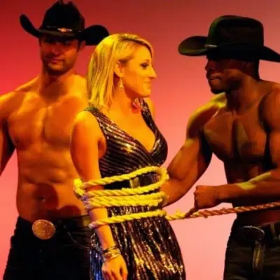 Dancers in cowboy hats tie up an audience member during Chippendales