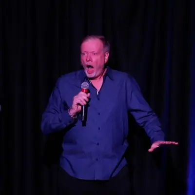 Comedian performing on stage at Delirious Comedy Club