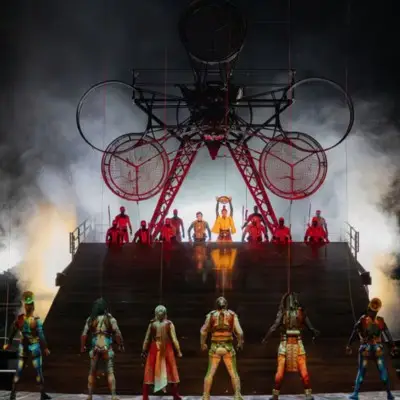 Performers on stage with a large mechanical structure and dramatic lighting during KÀ by Cirque du Soleil.