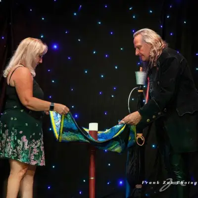 Losander performing levitation magic with an audience member at the Masters of Magic Show