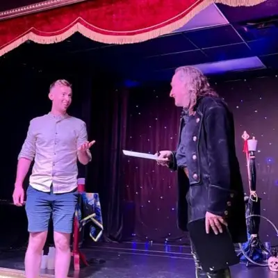 Losander performing tricks with audience member at the Candlelight Magic Show