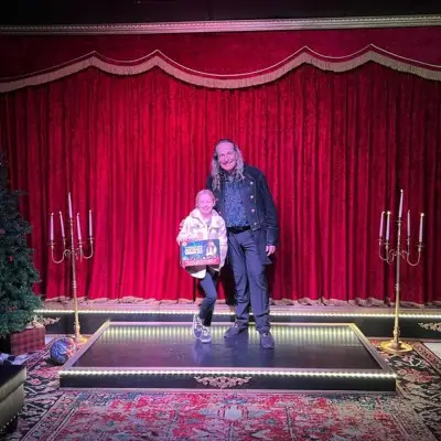 Losander posing with a child after the Magic Up Close show
