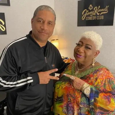 Luenell posing with a fan