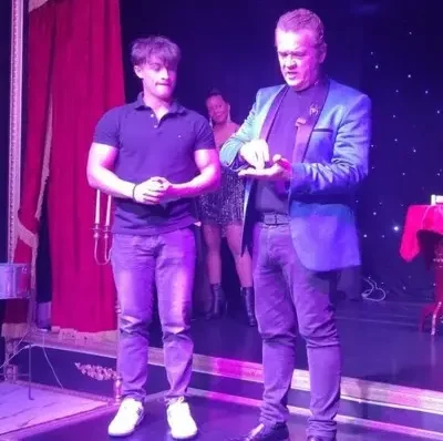 Magician performing magic with audience member at the Witches and Warlocks show