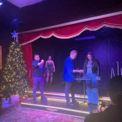 Magician posing with audience member after the Magic of Christmas Show