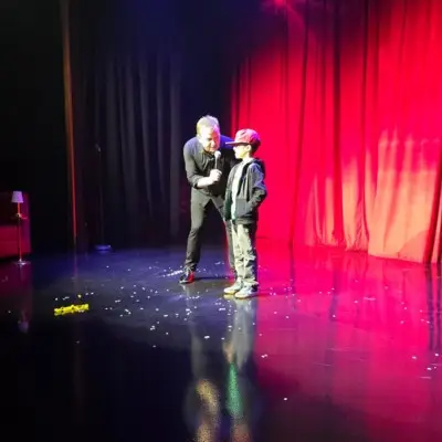 Nathan Burton on stage with a child