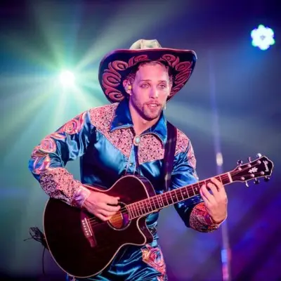 Performer playing a guitar at the Atomic Saloon Show