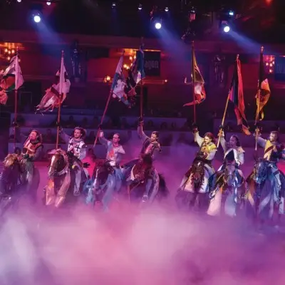 Performers on horses holding the flag of their representative country at the Tournament of Kings show