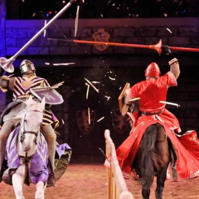 Performers in knights' costumes joust at the Tournament of Kings
