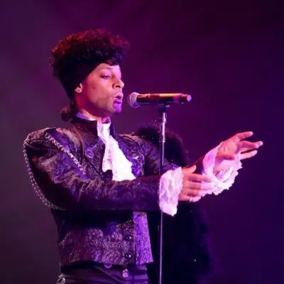 Purple Reign gestures with his hands while singing.