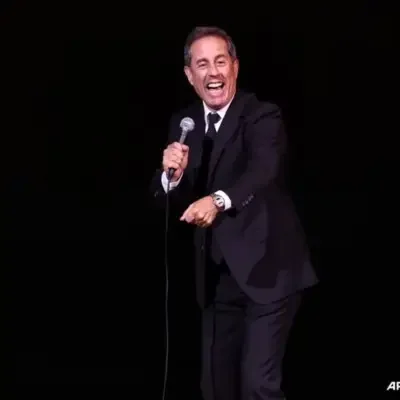 Jerry Seinfeld pointing at the audience while performing