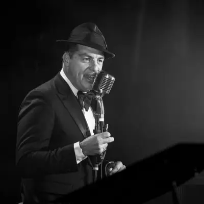 A black and white picture of the artist singing on stage in Las Vegas