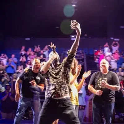 A picture of a comedian taking a selfie with fans