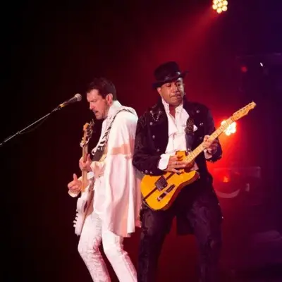 Two guitarists, one in white and one in black vintage clothes