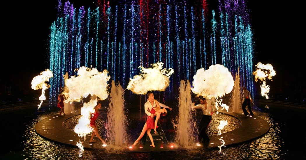 a night time performance with bright lights and fire effects